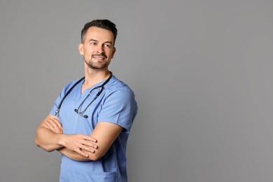 Smiling nurse with stethoscope on grey background, space for text