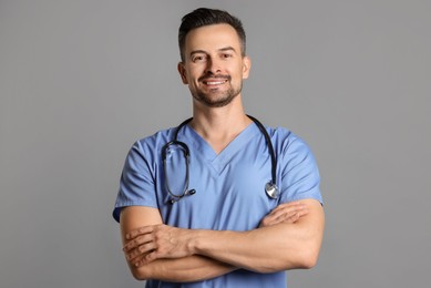 Photo of Smiling nurse with stethoscope on grey background