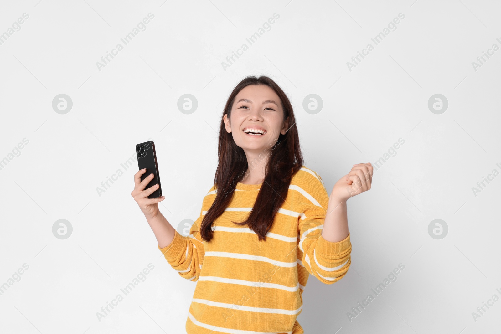 Photo of Smiling woman with smartphone on white background