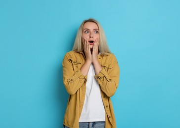 Photo of Portrait of scared woman on light blue background, space for text