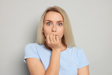 Portrait of scared woman on gray background