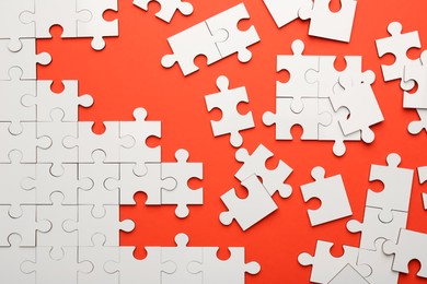 Photo of White puzzle pieces on red background, top view