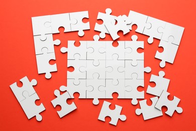 Photo of White puzzle pieces on red background, top view