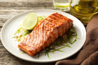 Photo of Delicious grilled salmon fillet served on wooden table, closeup