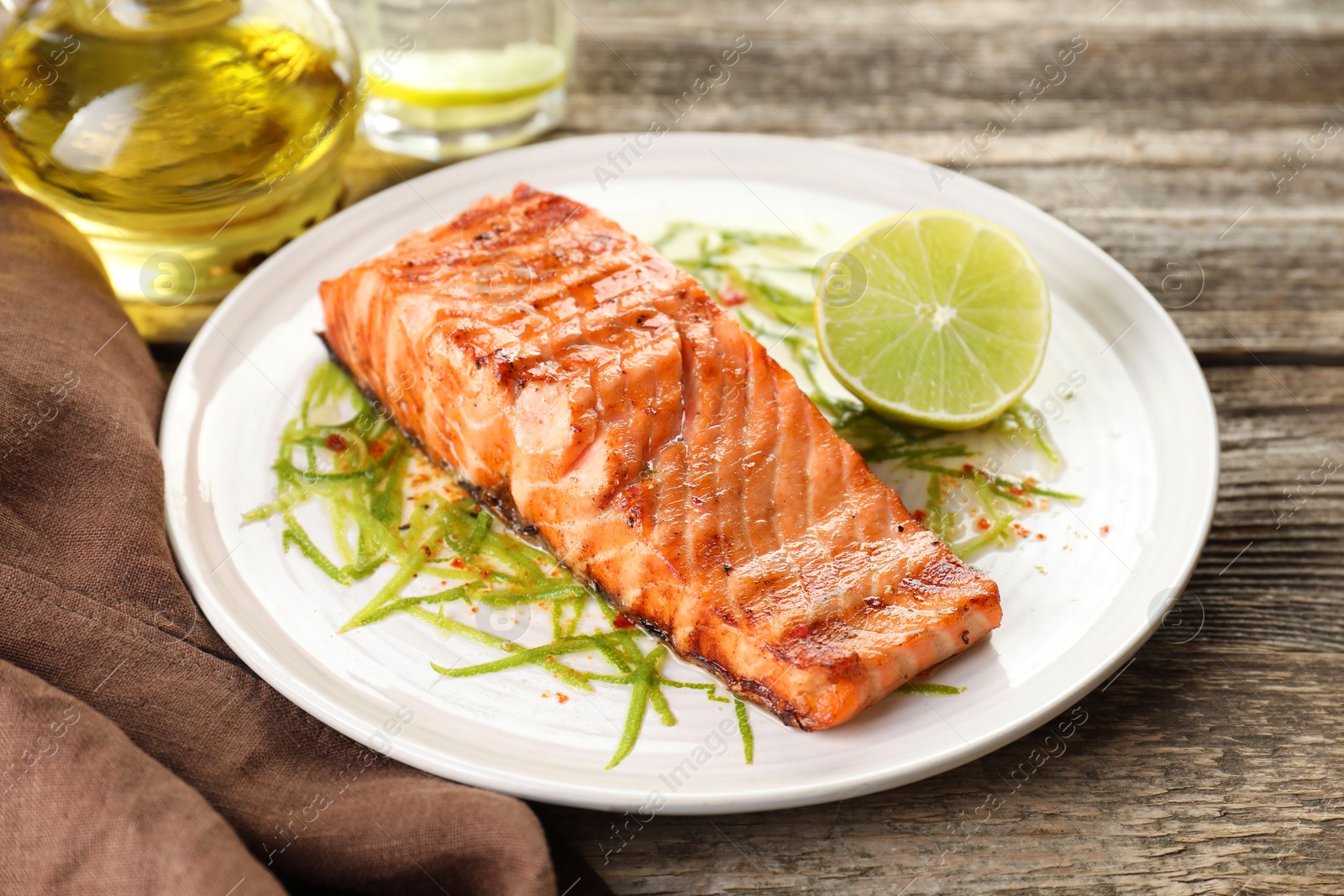 Photo of Delicious grilled salmon fillet served on wooden table, closeup