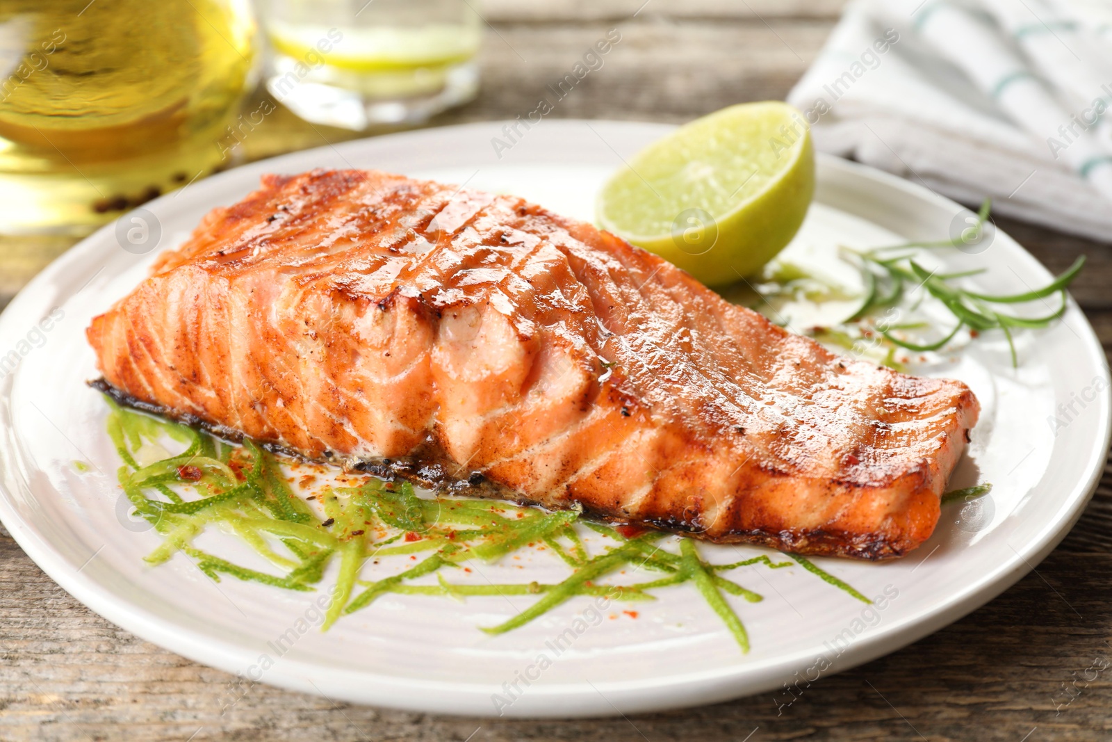 Photo of Delicious grilled salmon fillet served on wooden table, closeup