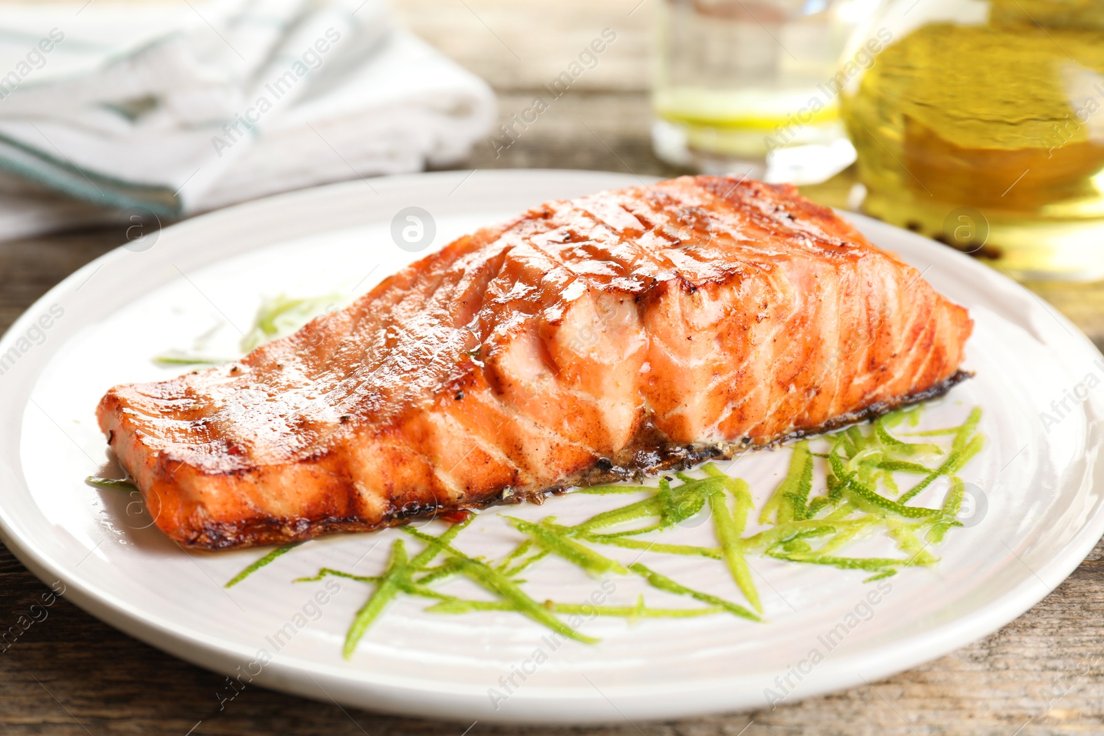 Photo of Delicious grilled salmon fillet served on wooden table, closeup