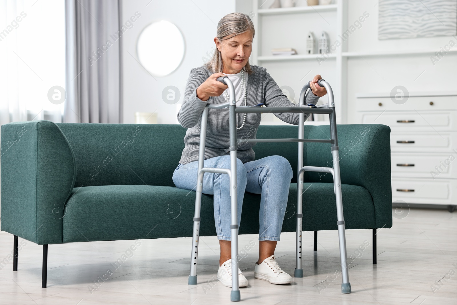 Photo of Senior woman with walking frame on sofa at home