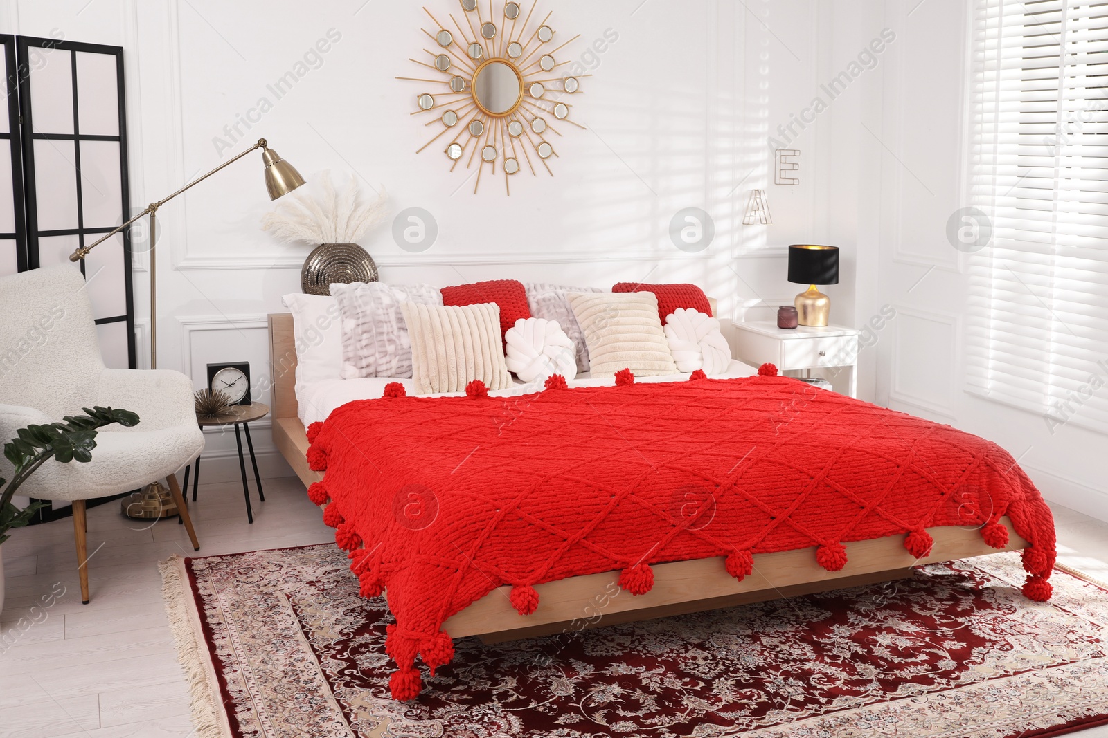 Photo of Big comfortable bed and decorative elements in room. Stylish bedroom interior