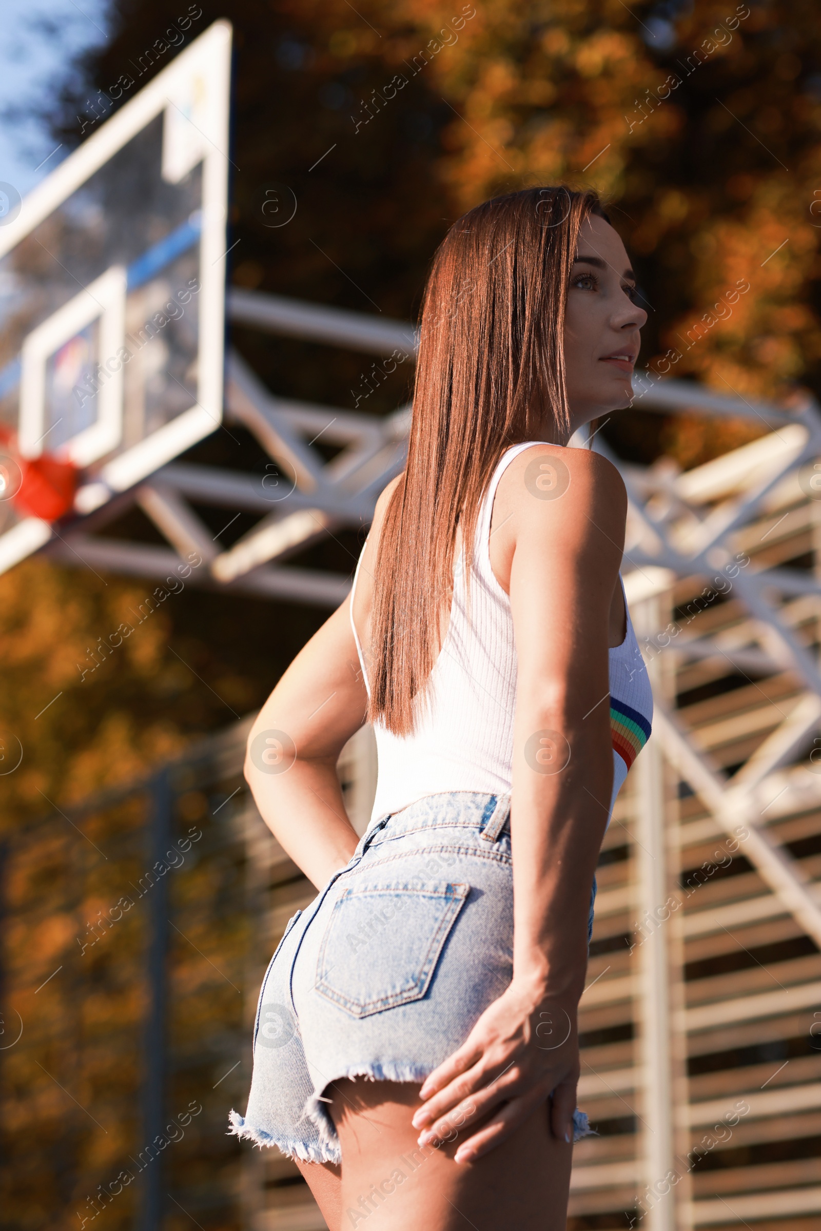 Photo of Beautiful woman wearing stylish denim shorts outdoors, low angle view