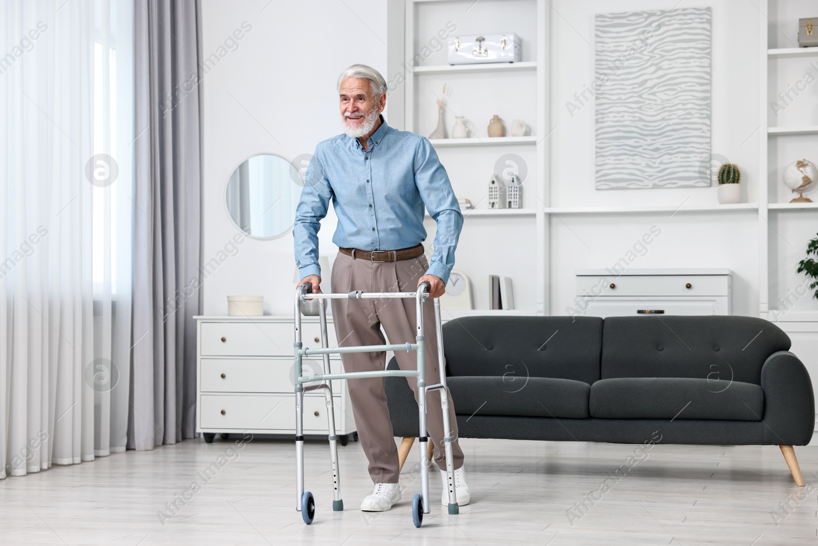 Photo of Senior man using walking frame at home