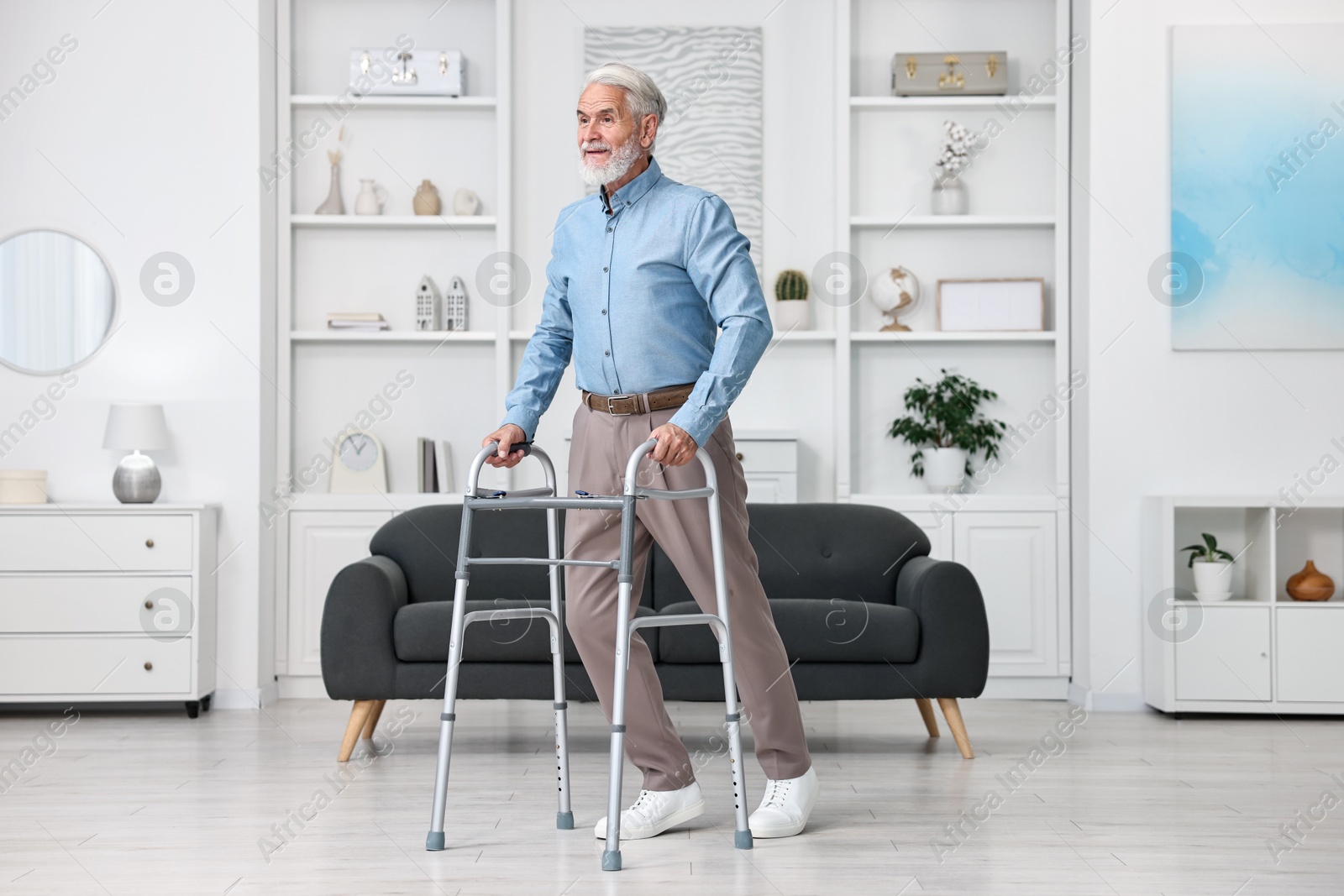 Photo of Senior man using walking frame at home