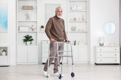 Senior man using walking frame at home