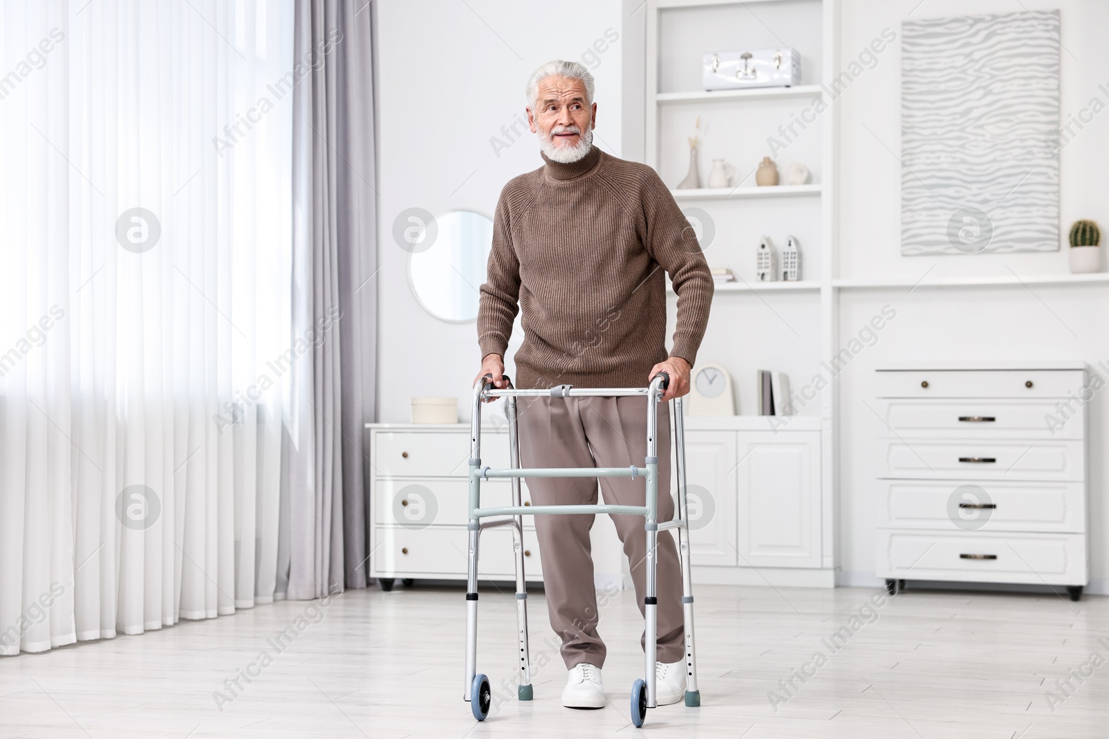 Photo of Senior man using walking frame at home