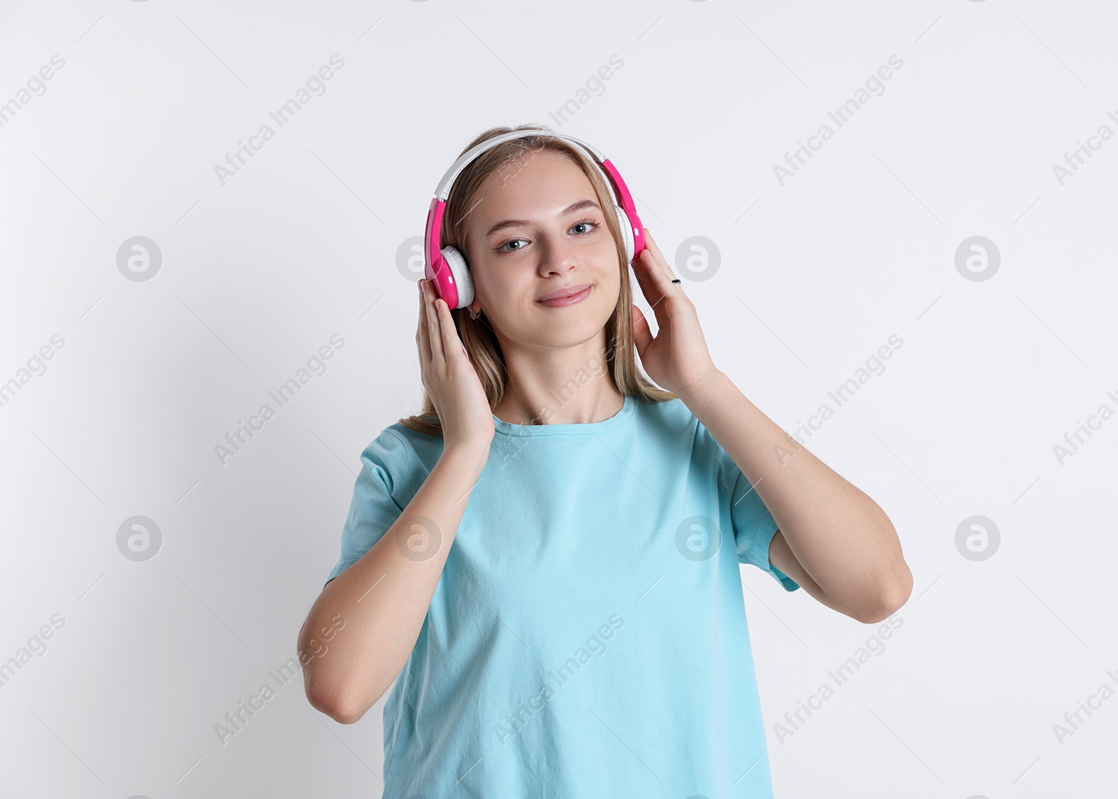 Photo of Portrait of teenage girl in headphones on white background