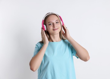 Portrait of teenage girl in headphones on white background