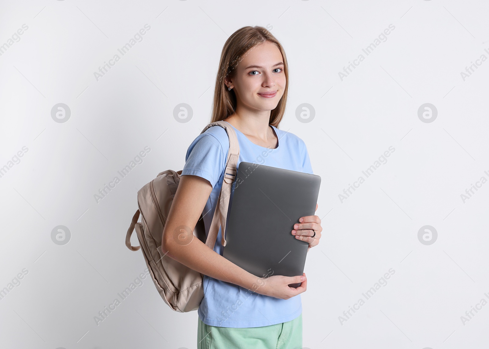 Photo of Teenage girl with laptop and backpack on white background