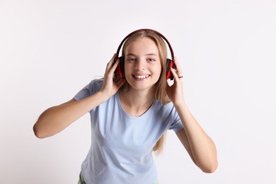 Photo of Teenage girl in headphones on white background