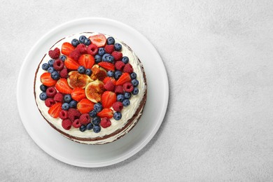 Photo of Delicious chocolate sponge cake with berries on light table, top view. Space for text