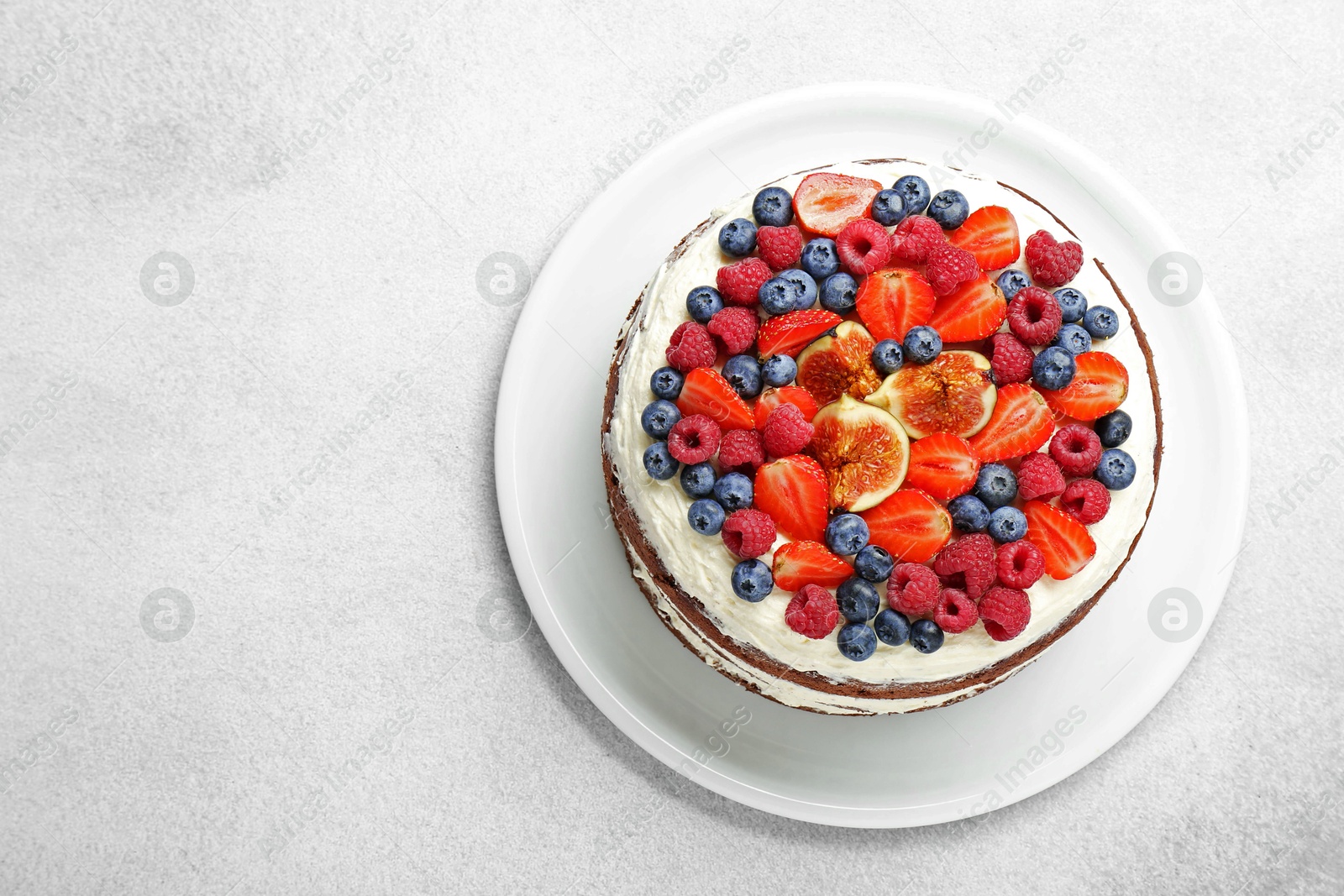 Photo of Delicious chocolate sponge cake with berries on light table, top view. Space for text