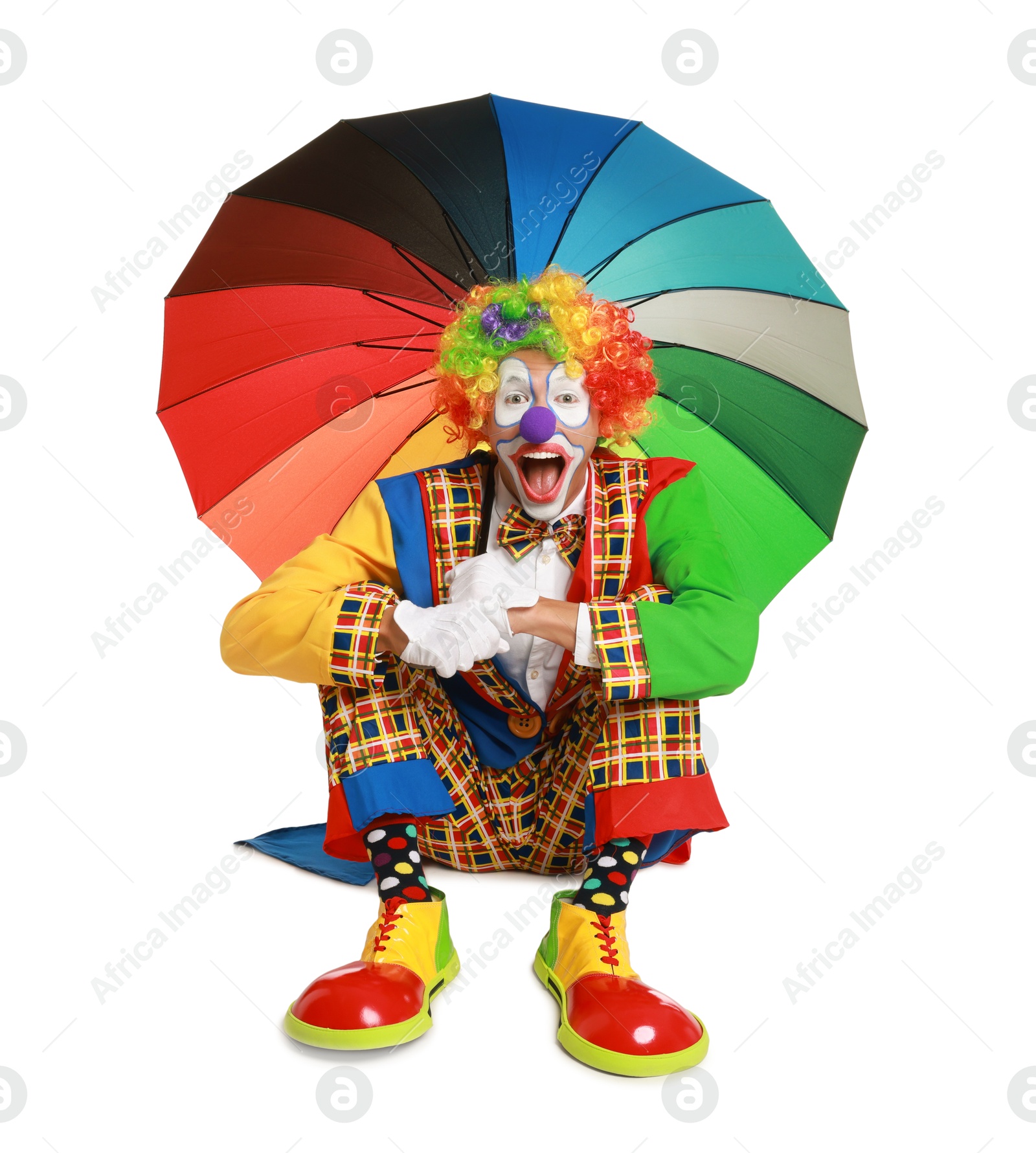 Photo of Emotional clown with colorful umbrella on white background