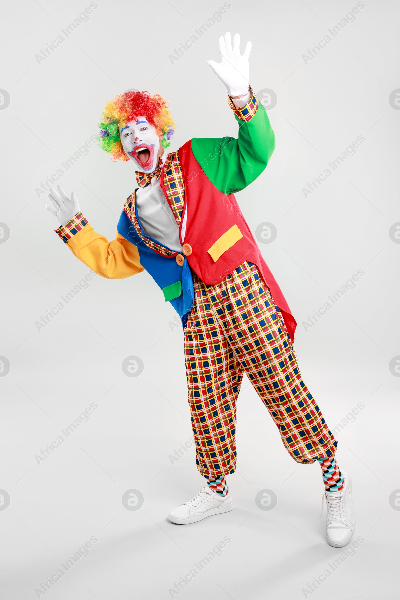 Photo of Portrait of emotional clown on light background