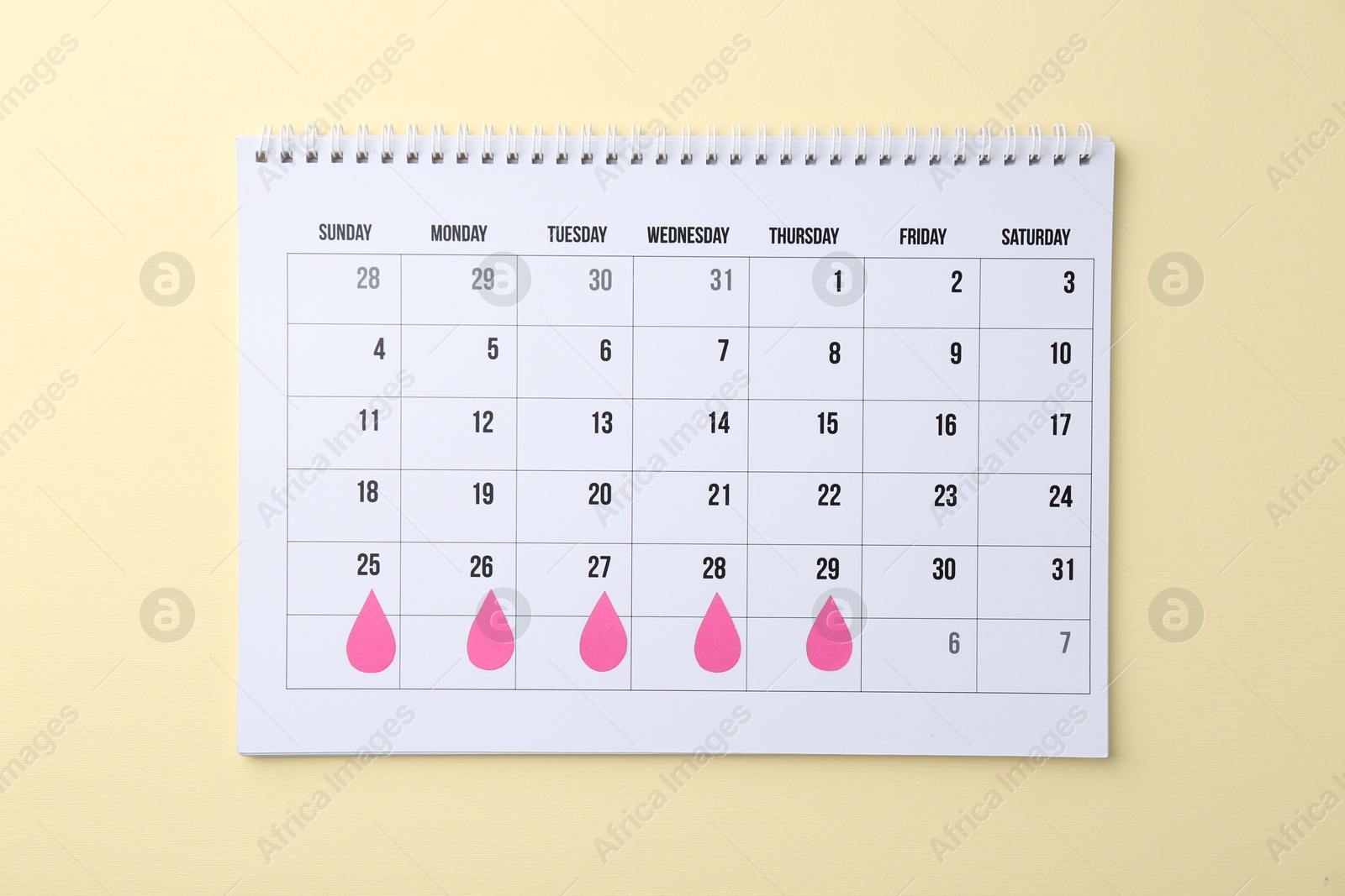 Photo of Menstruation. Calendar with marked dates on beige background, top view