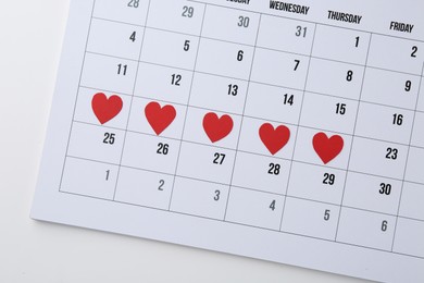 Photo of Menstruation. Calendar with marked dates on white background, top view