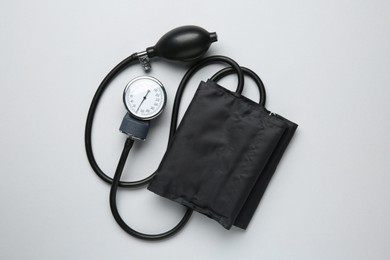 Photo of Blood pressure measuring device on light grey background, top view