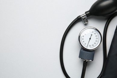 Photo of Blood pressure measuring device on light grey background, top view. Space for text