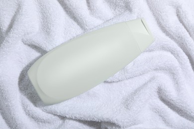 Shampoo in bottle on soft towel, top view