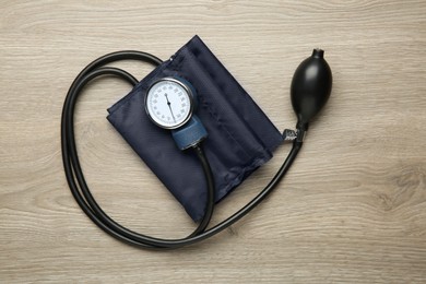 Photo of Blood pressure measuring device on wooden table, top view