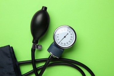 Photo of Blood pressure measuring device on green background, top view