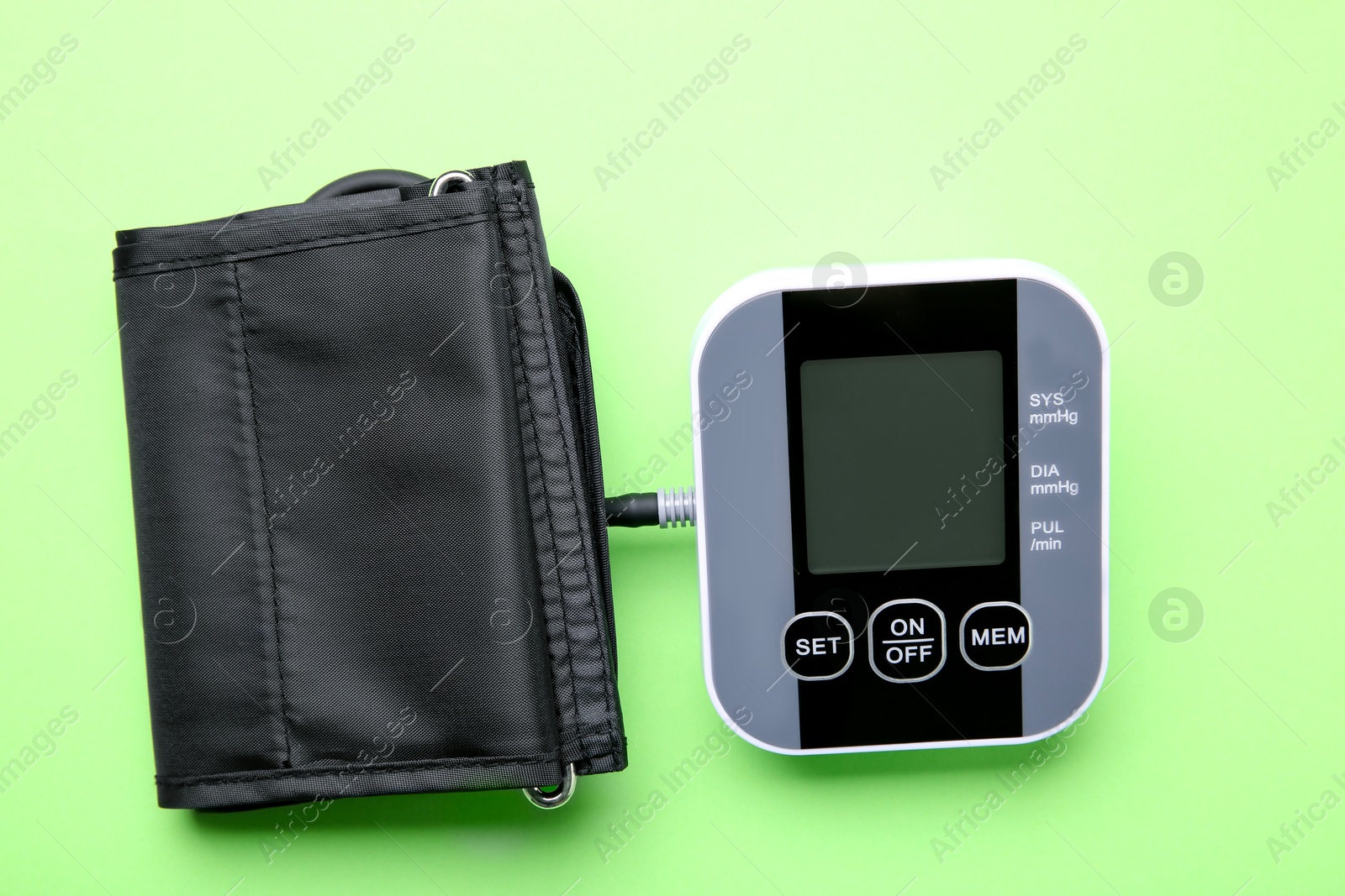 Photo of Blood pressure measuring device on green background, top view