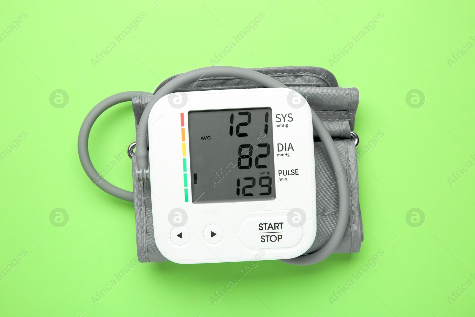 Photo of Blood pressure measuring device on green background, top view