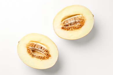 Photo of Halves of fresh melon on white background, top view