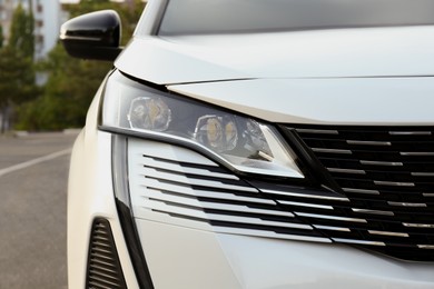 Photo of Closeup view of modern white car parked outdoors