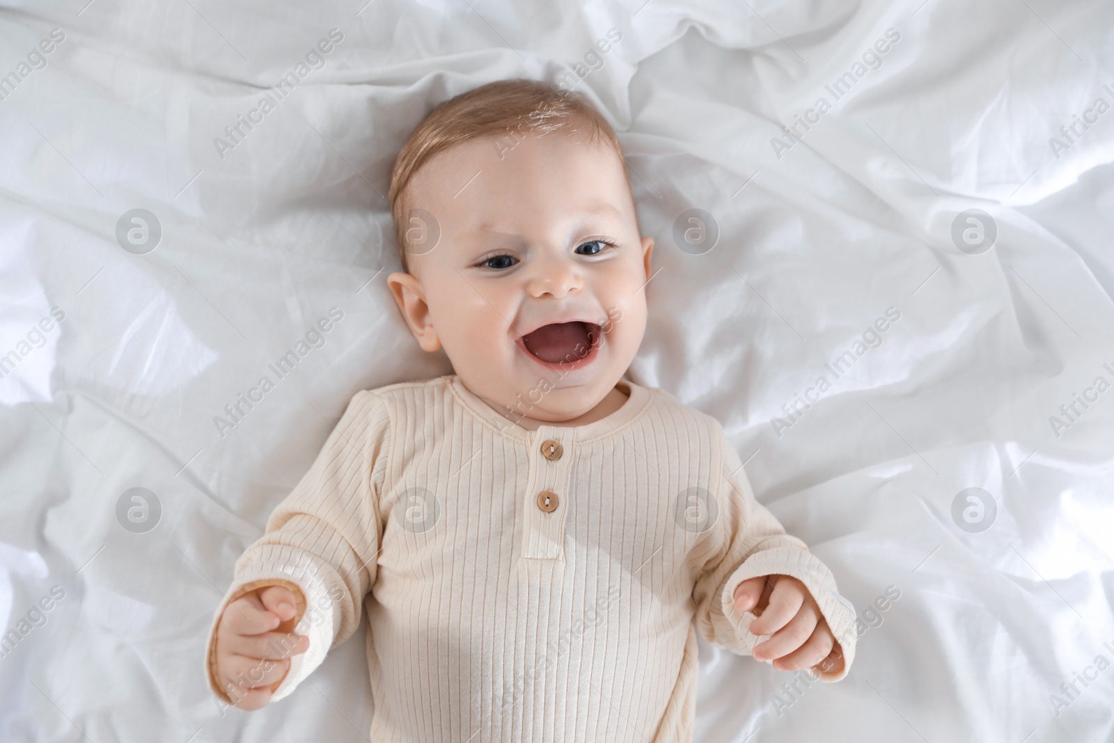 Photo of Cute little baby on bed indoors, top view