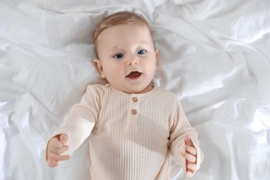 Cute little baby on bed indoors, top view