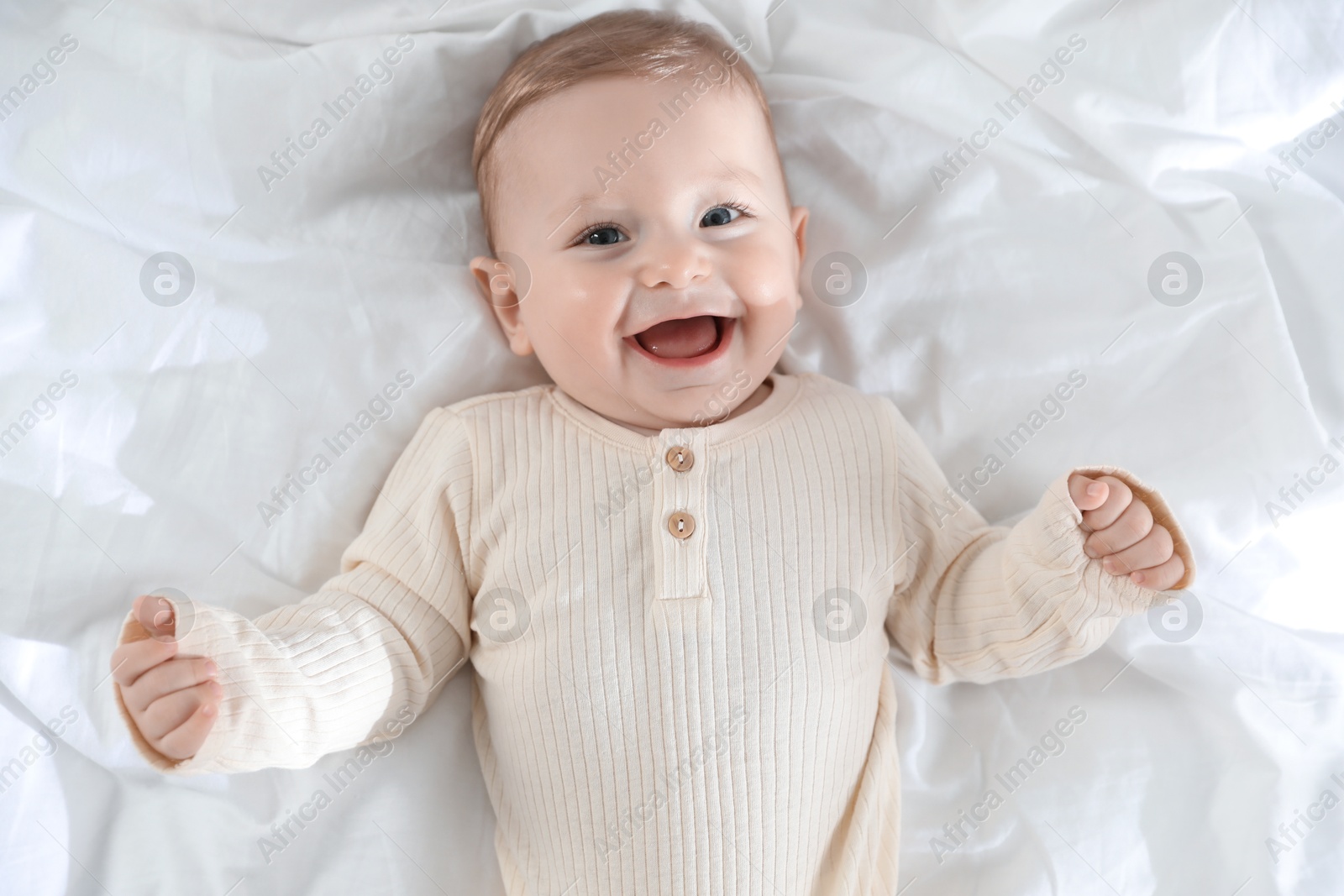 Photo of Cute little baby on bed indoors, top view