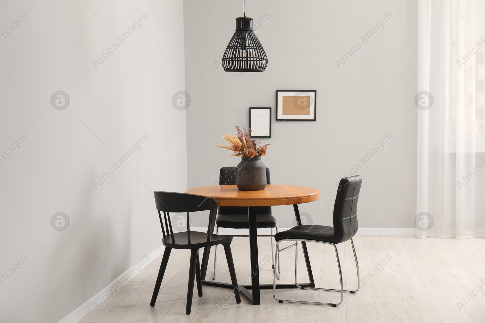 Photo of Wooden table with black chairs in stylish dining room