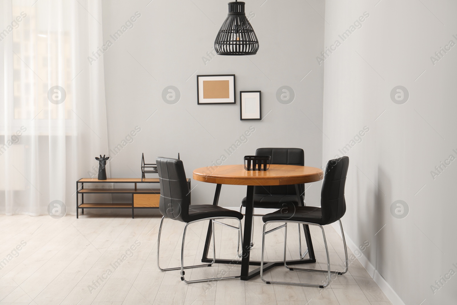 Photo of Wooden table with black chairs in stylish dining room