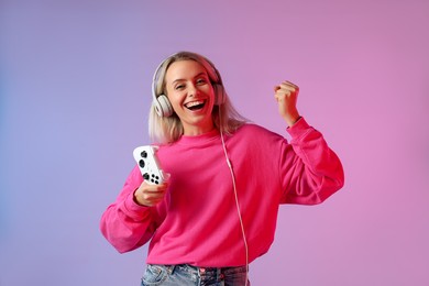 Happy woman with controller on color background