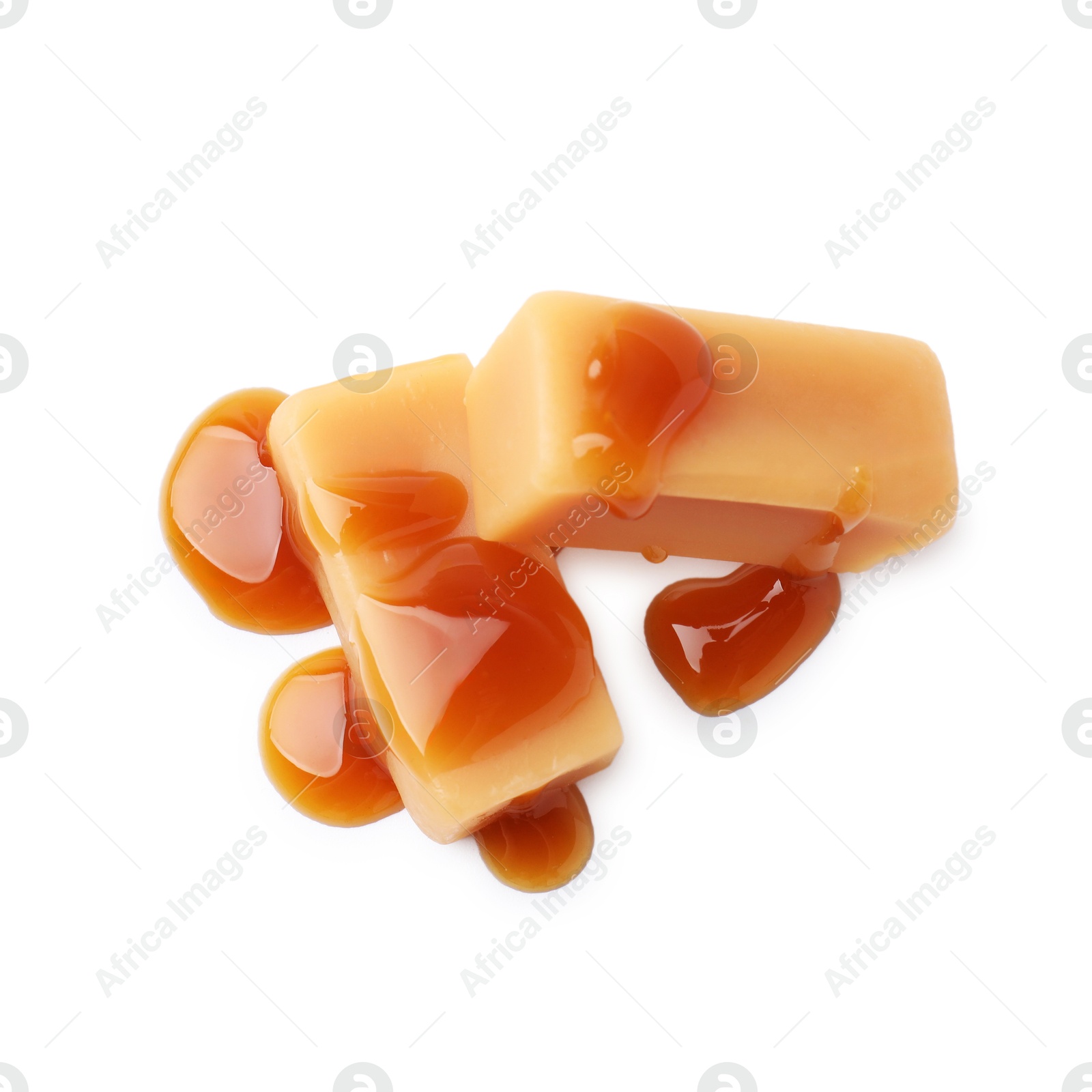 Photo of Tasty candies with caramel sauce isolated on white, top view