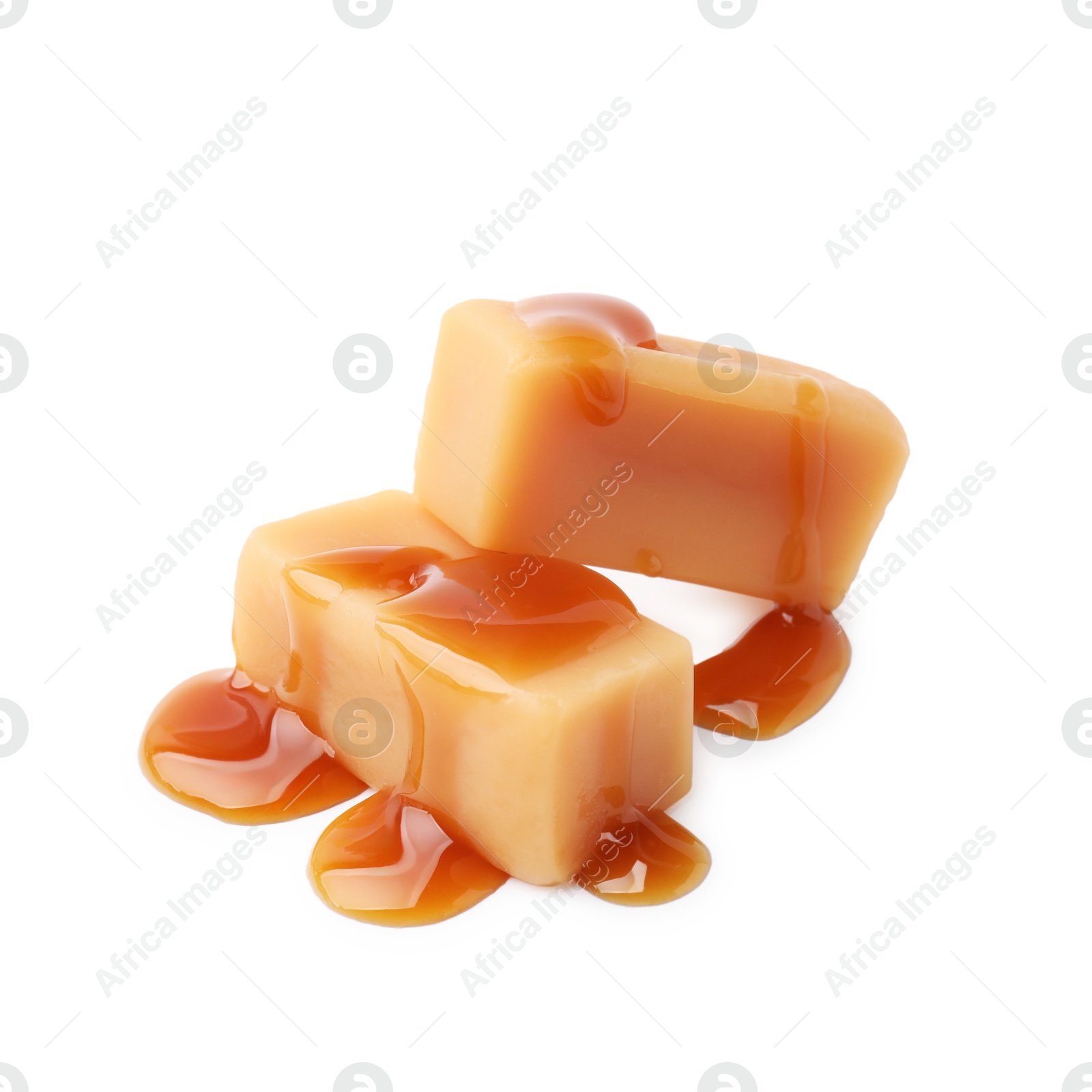 Photo of Tasty candies with caramel sauce isolated on white