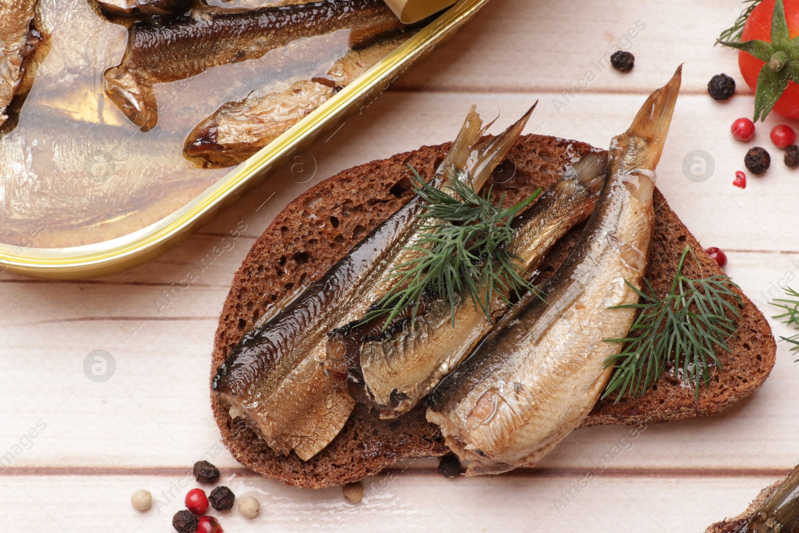 Photo of Delicious sandwich with sprats and dill served on white wooden table, top view