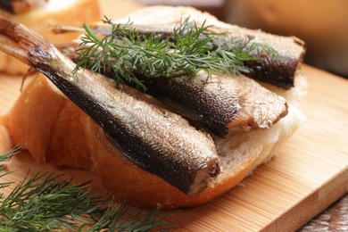 Photo of Delicious sandwich with sprats and dill on table, closeup