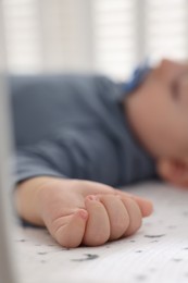 Cute baby sleeping in crib at home, closeup. Selective focus