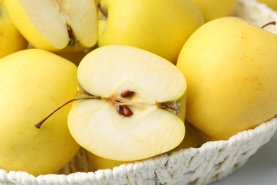 Photo of Fresh ripe yellow apples in basket on white table, closeup