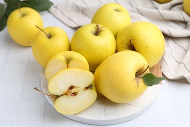 Photo of Fresh ripe yellow apples on white tiled table